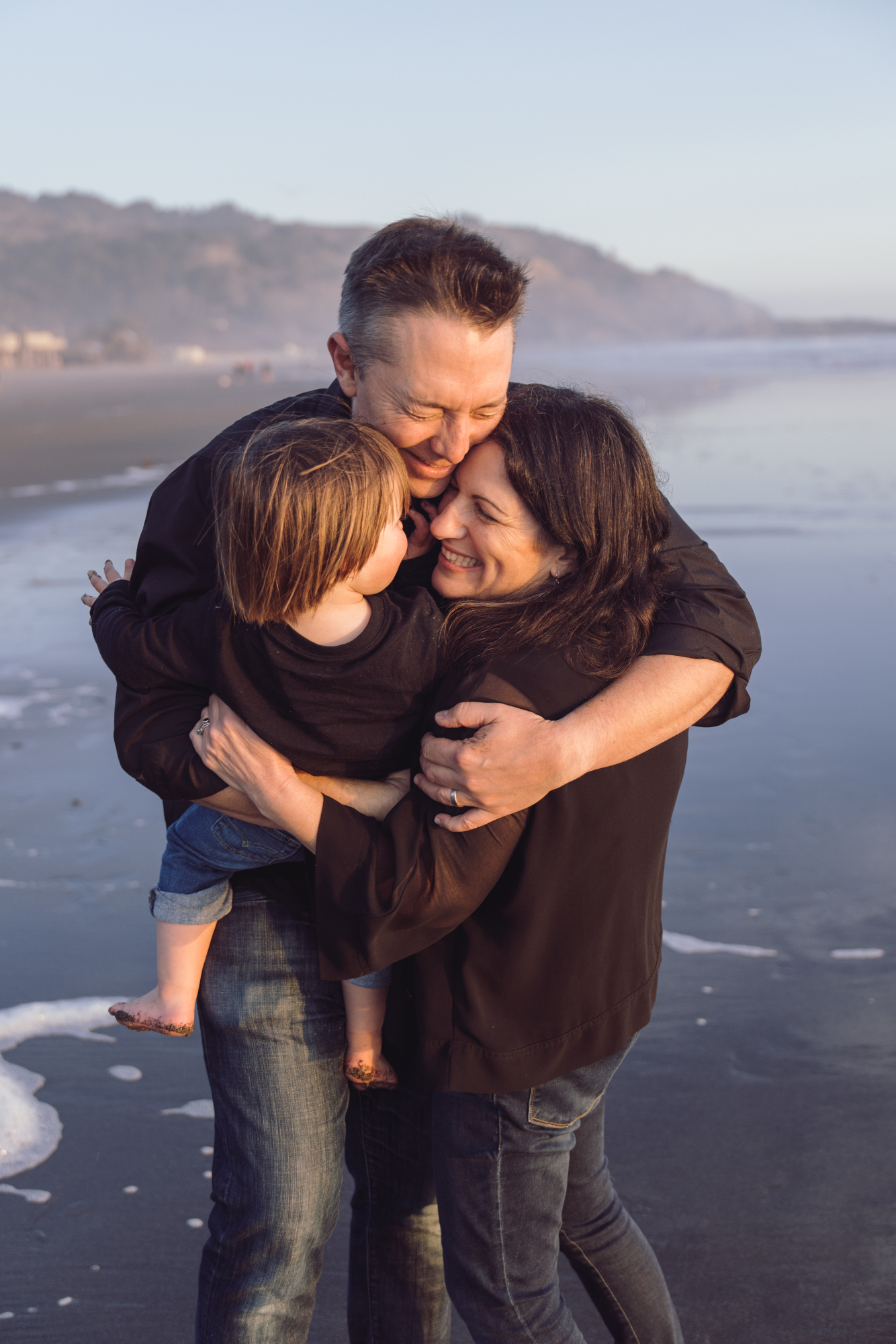 Family embracing in the surf on Bethany Beach
